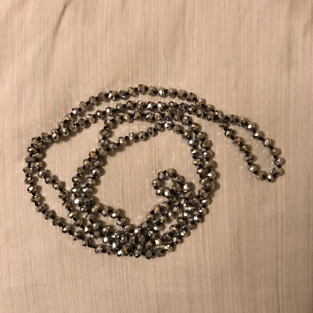 Long shiny silver necklace.